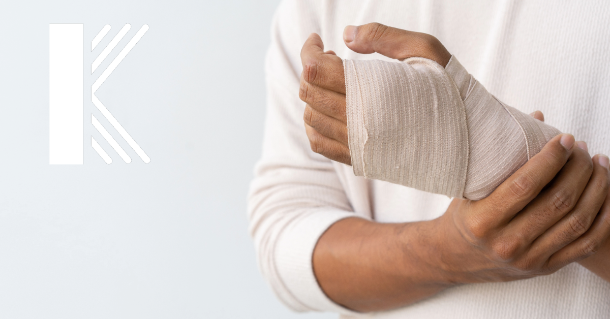 A person wearing a light-colored long-sleeve shirt wraps a bandage around their wrist, suggesting an injury. The image emphasizes the need for medical care and recovery, relevant to discussions about workers' compensation.